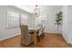 Traditional dining room boasts wood floors, modern lighting, and large windows for natural light at 39542 Friends Ave, Zephyrhills, FL 33540