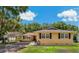 Charming single-story home featuring a carport, well-maintained lawn, and traditional architectural details at 39542 Friends Ave, Zephyrhills, FL 33540