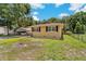 Cozy yellow home with dark shutters, a well-maintained lawn, and a fenced yard at 39542 Friends Ave, Zephyrhills, FL 33540