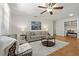 Inviting living room features a ceiling fan, neutral-toned walls and decor, and wood-look flooring at 39542 Friends Ave, Zephyrhills, FL 33540