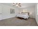 Sunlit main bedroom features carpet flooring, a ceiling fan, and a wooden bedframe at 39542 Friends Ave, Zephyrhills, FL 33540