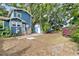 Exterior view of a two-story home, garage, and deck surrounded by mature trees in the backyard at 4016 N Seminole Ave, Tampa, FL 33603