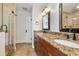 Bathroom with a dual vanity, granite countertop, and tiled shower enclosure at 4016 N Seminole Ave, Tampa, FL 33603