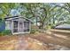Charming home featuring a screened porch, lush landscaping, and mature trees at 4016 N Seminole Ave, Tampa, FL 33603