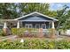 Charming blue two-story home features a covered porch, well-manicured landscaping and mature trees at 4016 N Seminole Ave, Tampa, FL 33603