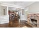 Open-concept living space with hardwood floors and a brick fireplace open to the kitchen at 4016 N Seminole Ave, Tampa, FL 33603