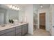 Bathroom featuring double sinks, stone countertops, a glass-enclosed shower, and modern fixtures at 4221 Goldfoil Rd, Spring Hill, FL 34609