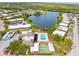 An aerial view of a residential area highlighting a community pool, shuffleboard, and nearby lake at 4305 Summersun Dr, New Port Richey, FL 34652