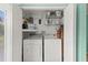 Laundry room features side-by-side washer and dryer units with storage shelves above at 4305 Summersun Dr, New Port Richey, FL 34652