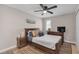 Bedroom with a ceiling fan, warm wood flooring, and a wooden bed with decorative pillows at 4623 Wisteria Dr, Zephyrhills, FL 33542