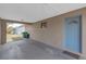 Carport view showcasing a blue entry door and access to the backyard and exterior at 4623 Wisteria Dr, Zephyrhills, FL 33542
