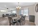 Open-concept dining room and living room with modern lighting, dark wood table, and wood-look flooring at 4623 Wisteria Dr, Zephyrhills, FL 33542