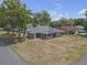 Charming single-story home featuring a gray exterior, mature trees, and a well-manicured front yard at 4623 Wisteria Dr, Zephyrhills, FL 33542