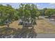 Inviting single-story home with mature trees, offering shade and curb appeal on a sunny day at 4623 Wisteria Dr, Zephyrhills, FL 33542