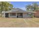 Charming single-story home featuring solar panels, gray exterior paint, and well-manicured landscaping at 4623 Wisteria Dr, Zephyrhills, FL 33542