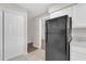 This kitchen has a large black refrigerator with white cabinets and neutral countertops at 4623 Wisteria Dr, Zephyrhills, FL 33542