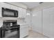 The kitchen has white cabinets, black appliances and neutral countertops at 4623 Wisteria Dr, Zephyrhills, FL 33542