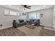 Bright living room featuring two gray sofas, modern window blinds, and wood-look floors at 4623 Wisteria Dr, Zephyrhills, FL 33542