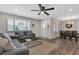 Spacious living room with wood-look flooring seamlessly connects to the dining area for easy entertaining at 4623 Wisteria Dr, Zephyrhills, FL 33542