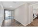 View of living room leading to the Primary bedroom, featuring new floors and sliding glass door at 4623 Wisteria Dr, Zephyrhills, FL 33542