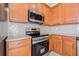 Close-up of the kitchen showcasing stainless steel oven, microwave, and wood cabinets at 5176 6Th N St, St Petersburg, FL 33703