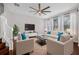 A well furnished living room with hardwood floors, fan, ample seating, a TV, and natural light at 5176 6Th N St, St Petersburg, FL 33703