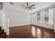 A spacious living room featuring hardwood floors and natural light from multiple windows and a fan at 5176 6Th N St, St Petersburg, FL 33703