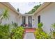 Home entrance featuring a cozy seating area with chairs and lush landscaping at 5219 4Th S St, St Petersburg, FL 33705
