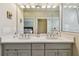 Well-lit bathroom with double sinks, white countertop, and a glass-enclosed shower area at 6140 Marina Cove S Way, St Petersburg, FL 33712