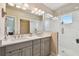 Elegant bathroom featuring double sinks, a marble-tiled shower, and modern lighting fixtures at 6140 Marina Cove S Way, St Petersburg, FL 33712