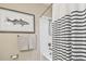Stylish bathroom with nautical striped shower curtain, framed fish art, and light grey hand towels at 6140 Marina Cove S Way, St Petersburg, FL 33712