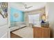 Charming Bedroom with two cribs, a bright accent wall, and plenty of natural light from the window at 6140 Marina Cove S Way, St Petersburg, FL 33712