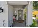 Charming covered front porch with gray tiled floor, house number, lantern, potted plants, and a decorative front door at 6140 Marina Cove S Way, St Petersburg, FL 33712