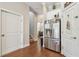 Hallway with hardwood floors leading to the kitchen with stainless steel refrigerator at 6140 Marina Cove S Way, St Petersburg, FL 33712