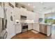 Well-lit kitchen with white cabinets, stainless steel appliances, and hardwood floors at 6140 Marina Cove S Way, St Petersburg, FL 33712