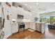 Modern kitchen with white cabinets, stainless steel appliances, and hardwood floors at 6140 Marina Cove S Way, St Petersburg, FL 33712