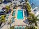 Relaxing pool area with lounge chairs, palm trees, and tiki huts for shade at 6140 Marina Cove S Way, St Petersburg, FL 33712