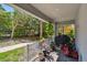 Covered porch with brick flooring, potted plants, and outdoor seating overlooking the yard at 6140 Marina Cove S Way, St Petersburg, FL 33712
