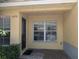 Inviting covered townhome entrance with brick flooring and lush landscaping at 6250 Maisie Rd, Zephyrhills, FL 33542