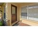 Close up of townhome front door with brick entryway and neutral colors at 6250 Maisie Rd, Zephyrhills, FL 33542