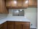 Kitchen displaying light countertops, wooden cabinets, and pass-through window to living area at 6250 Maisie Rd, Zephyrhills, FL 33542