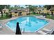 View of the community pool with lounge chairs and umbrella at 6250 Maisie Rd, Zephyrhills, FL 33542