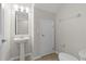 Cozy powder room with pedestal sink, wall mirror, and tile flooring at 6250 Maisie Rd, Zephyrhills, FL 33542