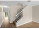 Hallway with staircase featuring white railings, neutral walls, and wood-look flooring at 6250 Maisie Rd, Zephyrhills, FL 33542