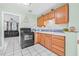 Cozy kitchen featuring wooden cabinets, black appliances, and tile backsplash at 653 E Spruce St, Tarpon Springs, FL 34689