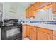 Cozy kitchen featuring wooden cabinets, black appliances, and tile backsplash at 653 E Spruce St, Tarpon Springs, FL 34689