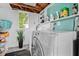 Bright laundry area featuring modern washer and dryer, storage shelves, and natural light from the window at 653 E Spruce St, Tarpon Springs, FL 34689