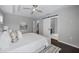 Bedroom featuring barn door entry to bathroom, white bedding, and dark wood floor at 7307 S Trask St, Tampa, FL 33616