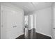 Bright hallway with hardwood floors, white doors, and access to multiple rooms, creating a seamless transition in the home at 7307 S Trask St, Tampa, FL 33616