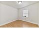 Clean bedroom with light hardwood floors, white trim, neutral walls, and a sunny window at 8704 N Brooks St, Tampa, FL 33604